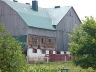 Closeup of grey barn with green metal roof